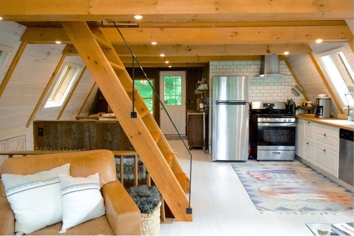 Salon et cuisine d'un chalet en bois prêt à accueillir des invités